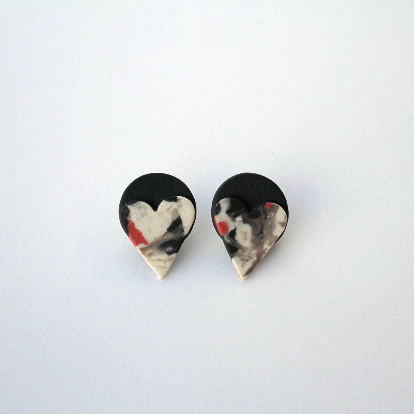 Detalle de pendientes corazón marmoleado de porcelana artesanal BIHU