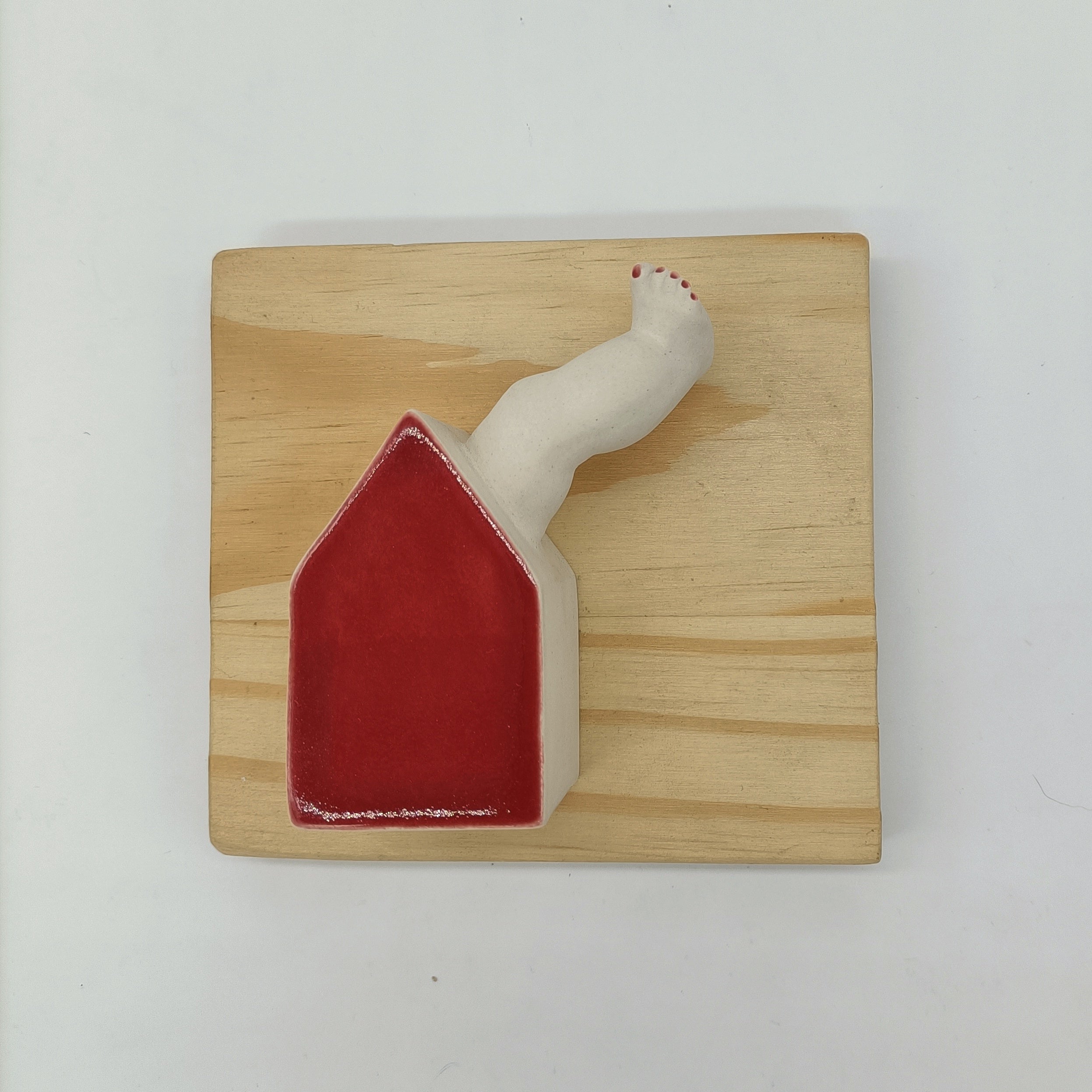 Casa roja con chimenea colgada en pared como decoración artesanal