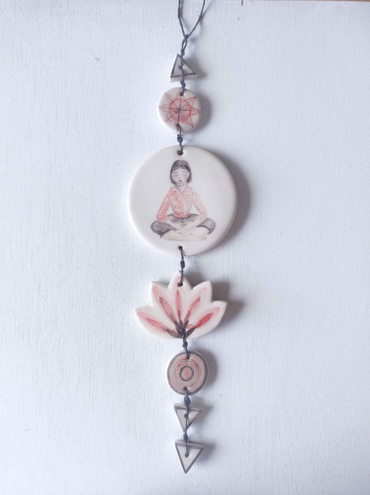 Colgante pared cerámica chica meditando rojo y negro yoga
