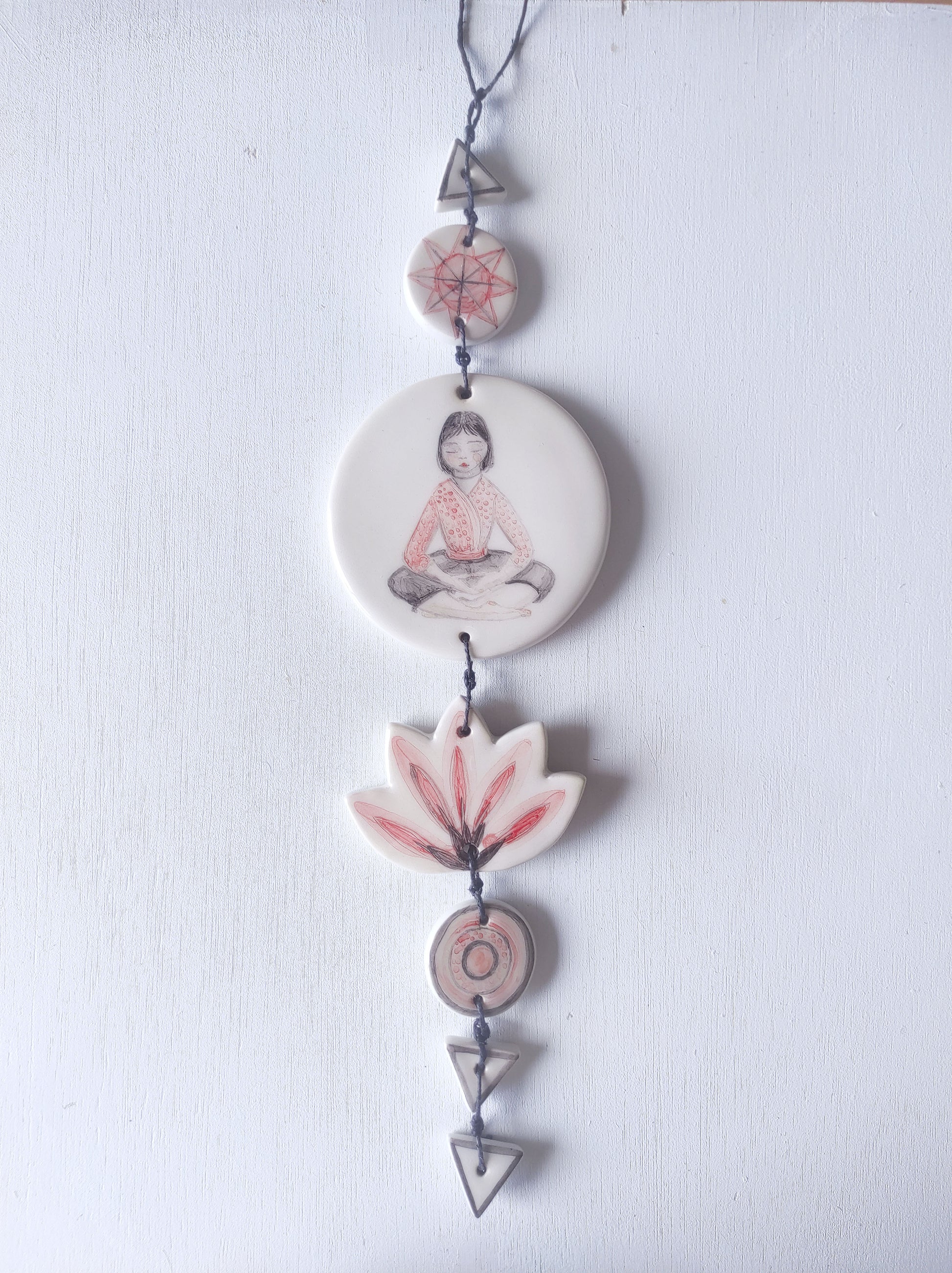 Colgante pared cerámica chica meditando rojo y negro yoga
