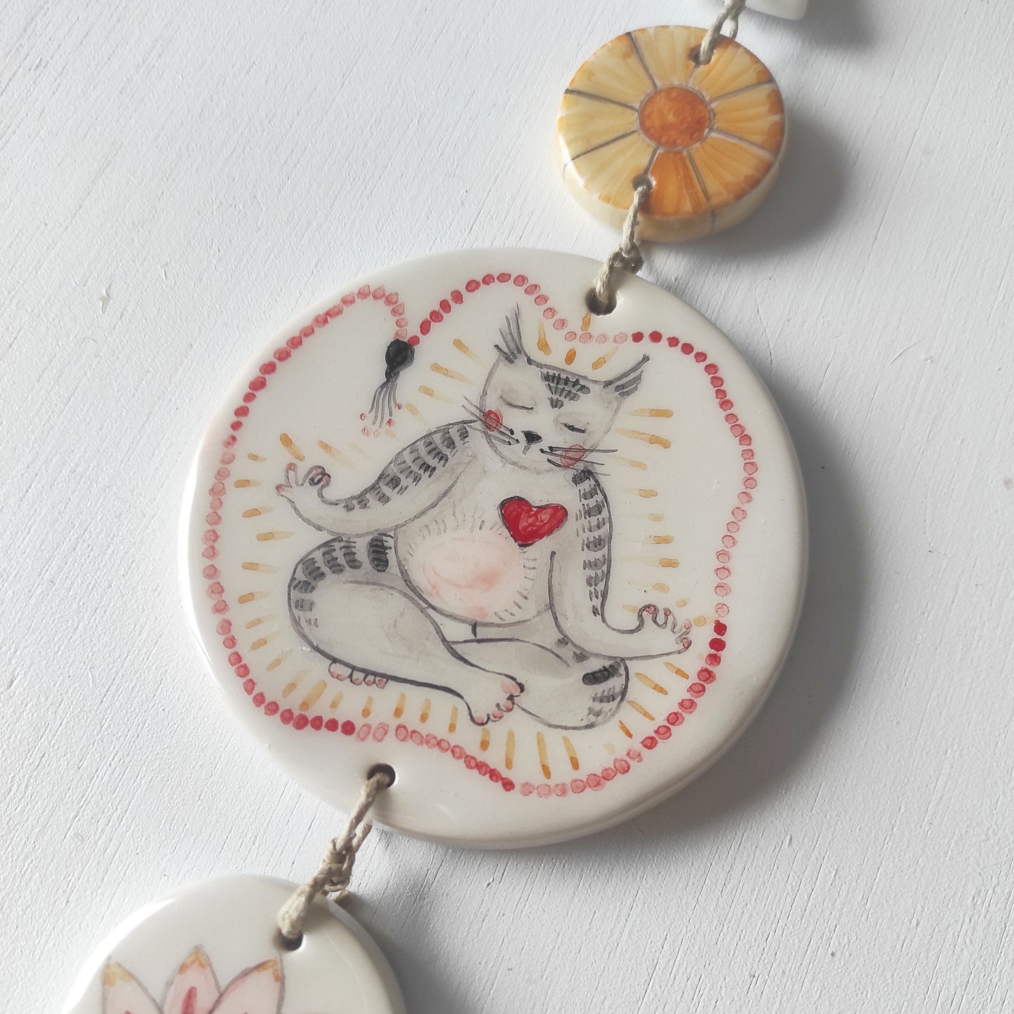 Detalle colgante pared loza esmaltada gato yoga japa mala BIHU
