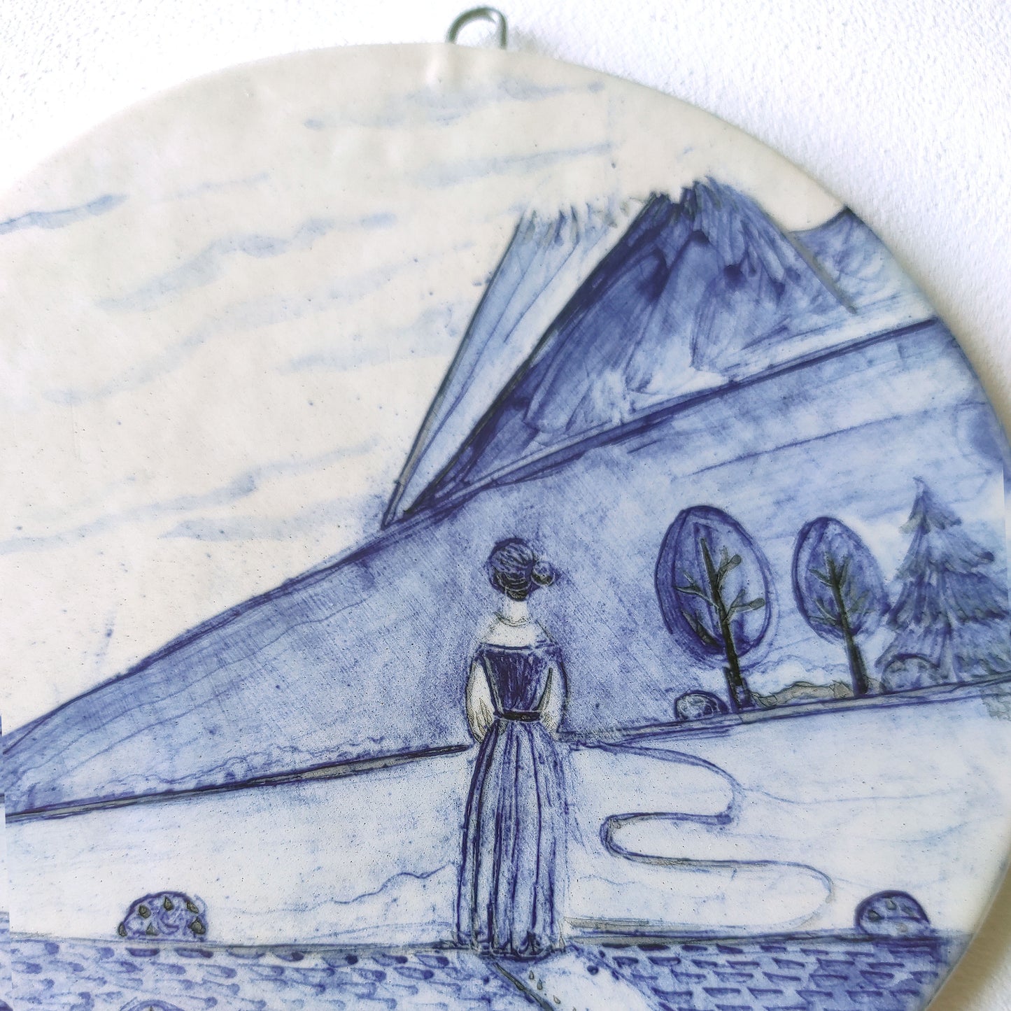 Detalle colgante pared loza esmaltada mujer caminando paisaje BIHU
