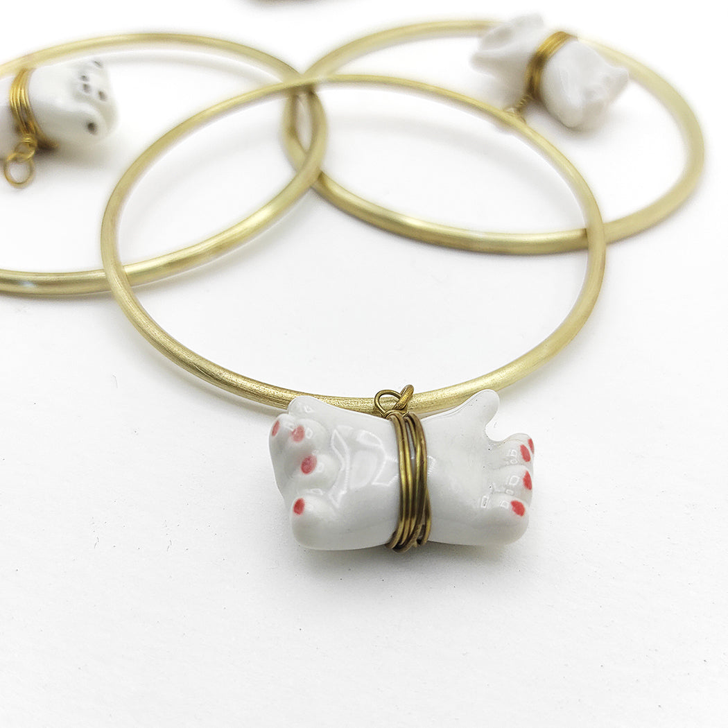 Detalle de colgante manos dobles porcelana esmaltada y latón BIHU