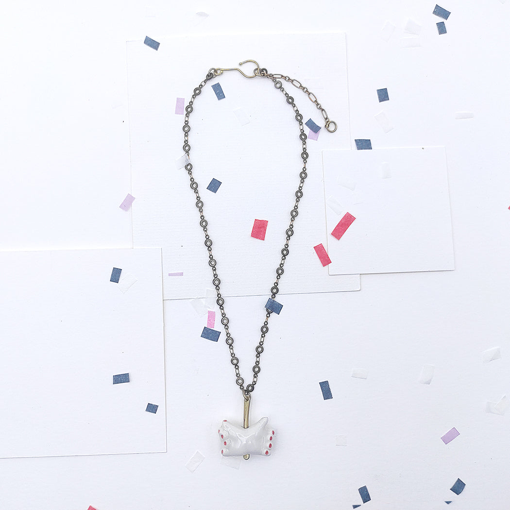 Detalle de collar manos dobles porcelana esmaltada y latón BIHU uñas rojas