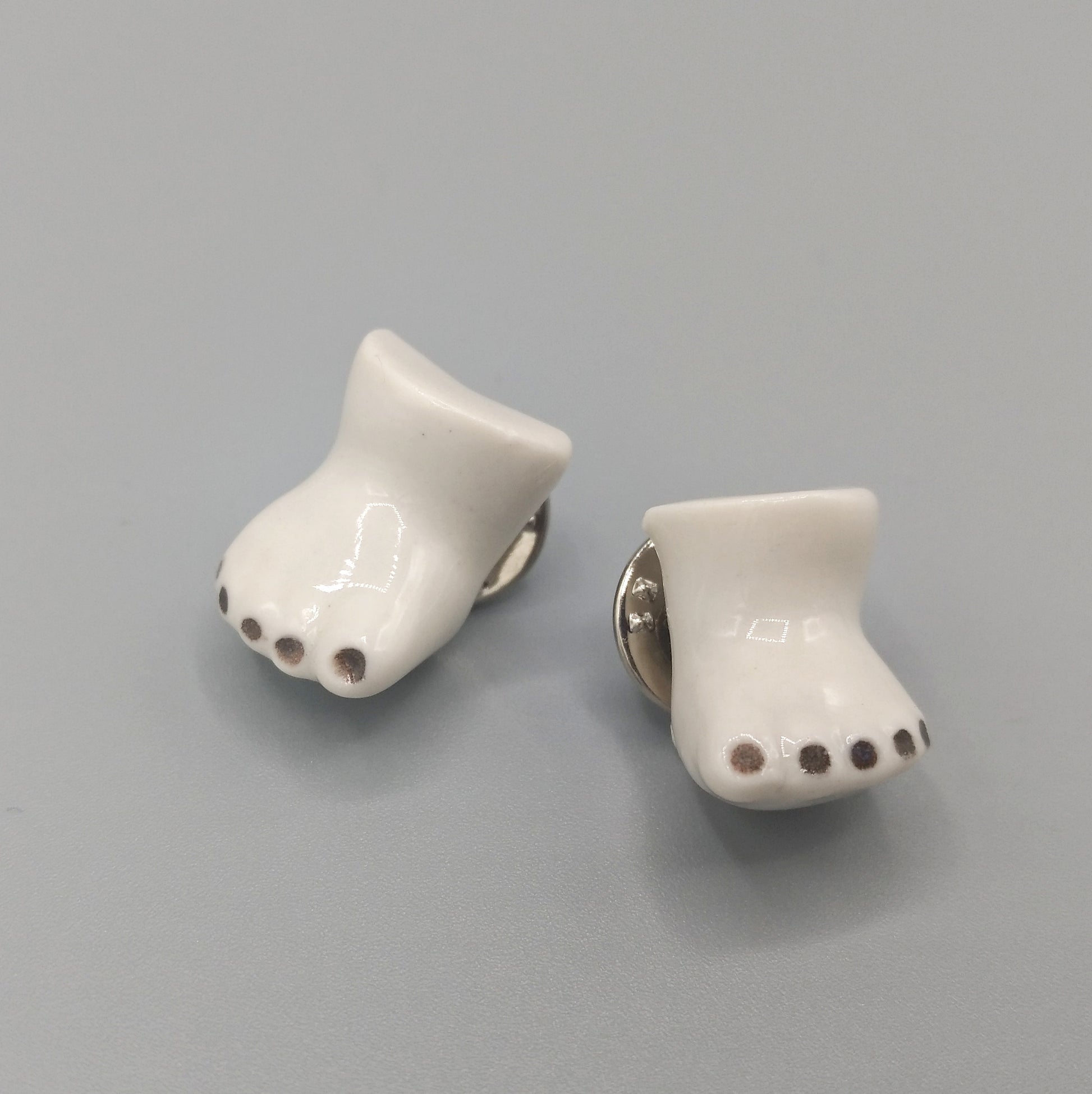 Detalle de pins pies porcelana esmaltada BIHU uñas negras