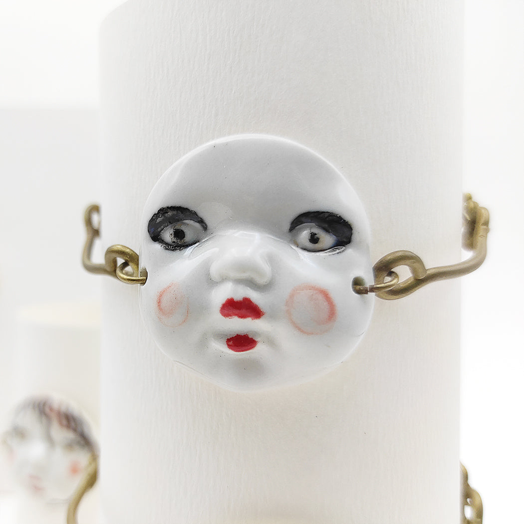 Detalle pulsera ajustable caritas con distintos motivos porcelana ojos negros sin pecas