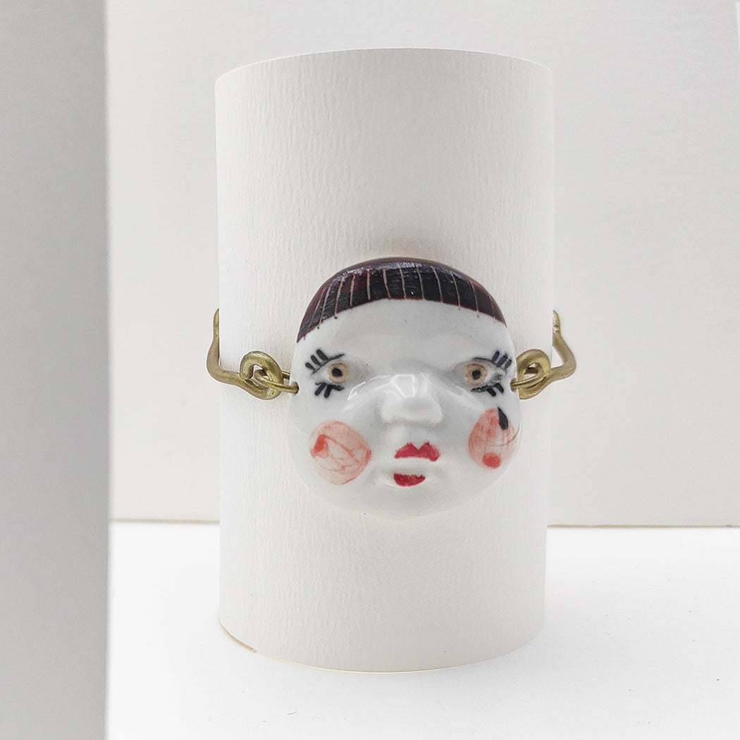 Detalle de pulsera caritas flequillo porcelana esmaltada y latón BIHU