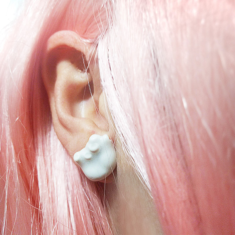 Mujer luciendo pendientes manitas de porcelana y plata