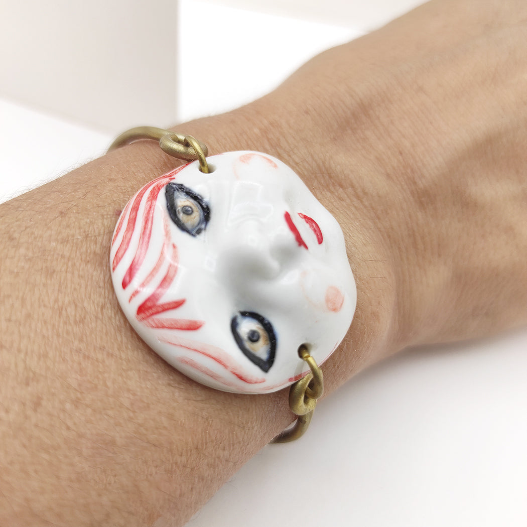 Mujer luciendo pulsera caritas de porcelana y latón