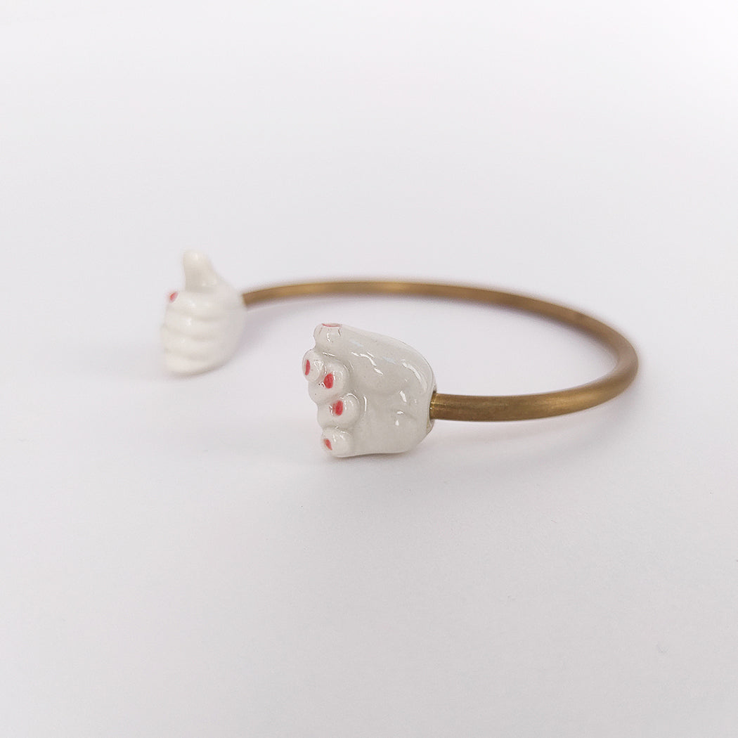 Pulsera abierta dos manos de latón con porcelana blanca esmaltada uñas rojas
