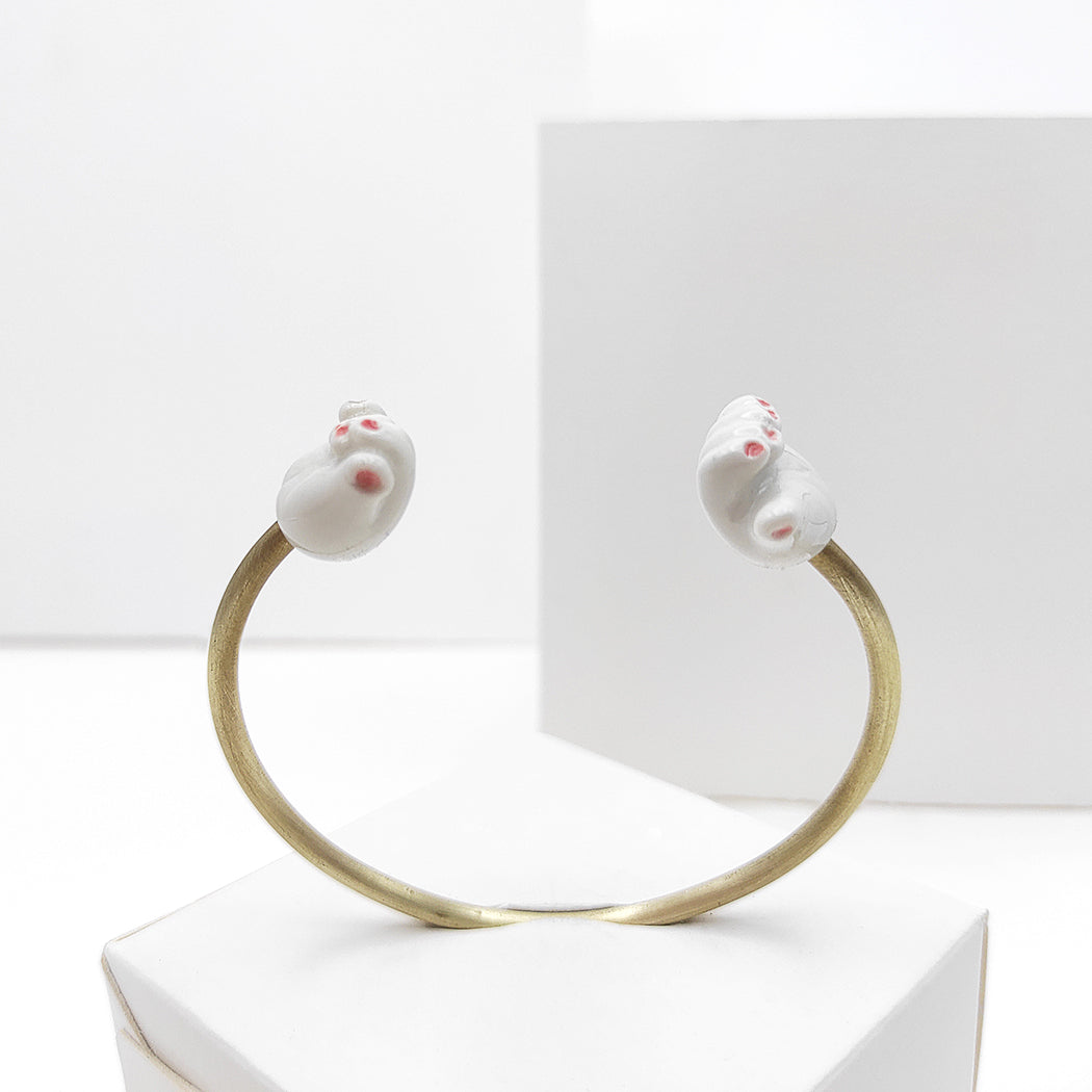 Pulsera abierta latón con dos manos porcelana diseño ajustable uñas pintadas de rojo